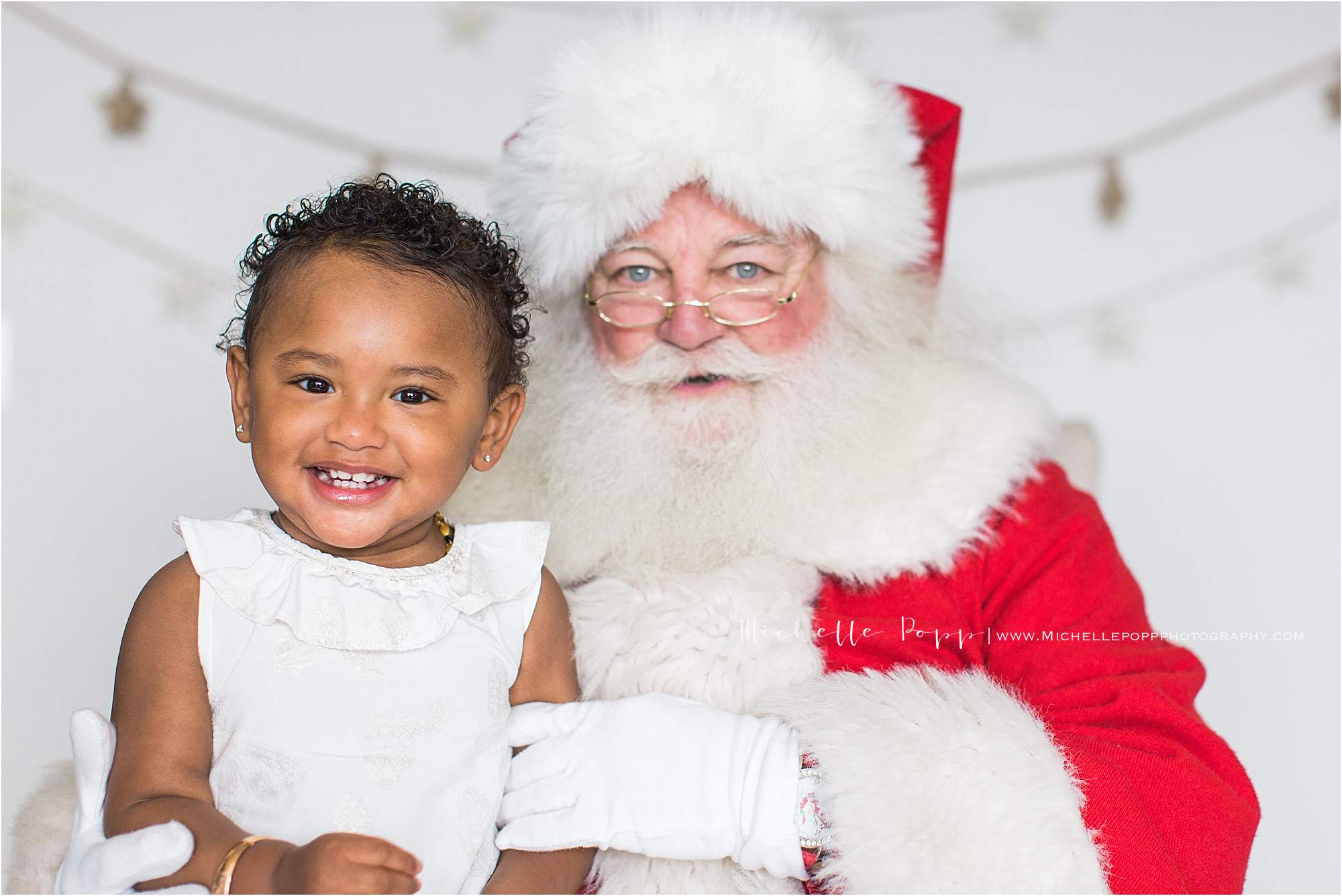 little girl smiling next to Santa