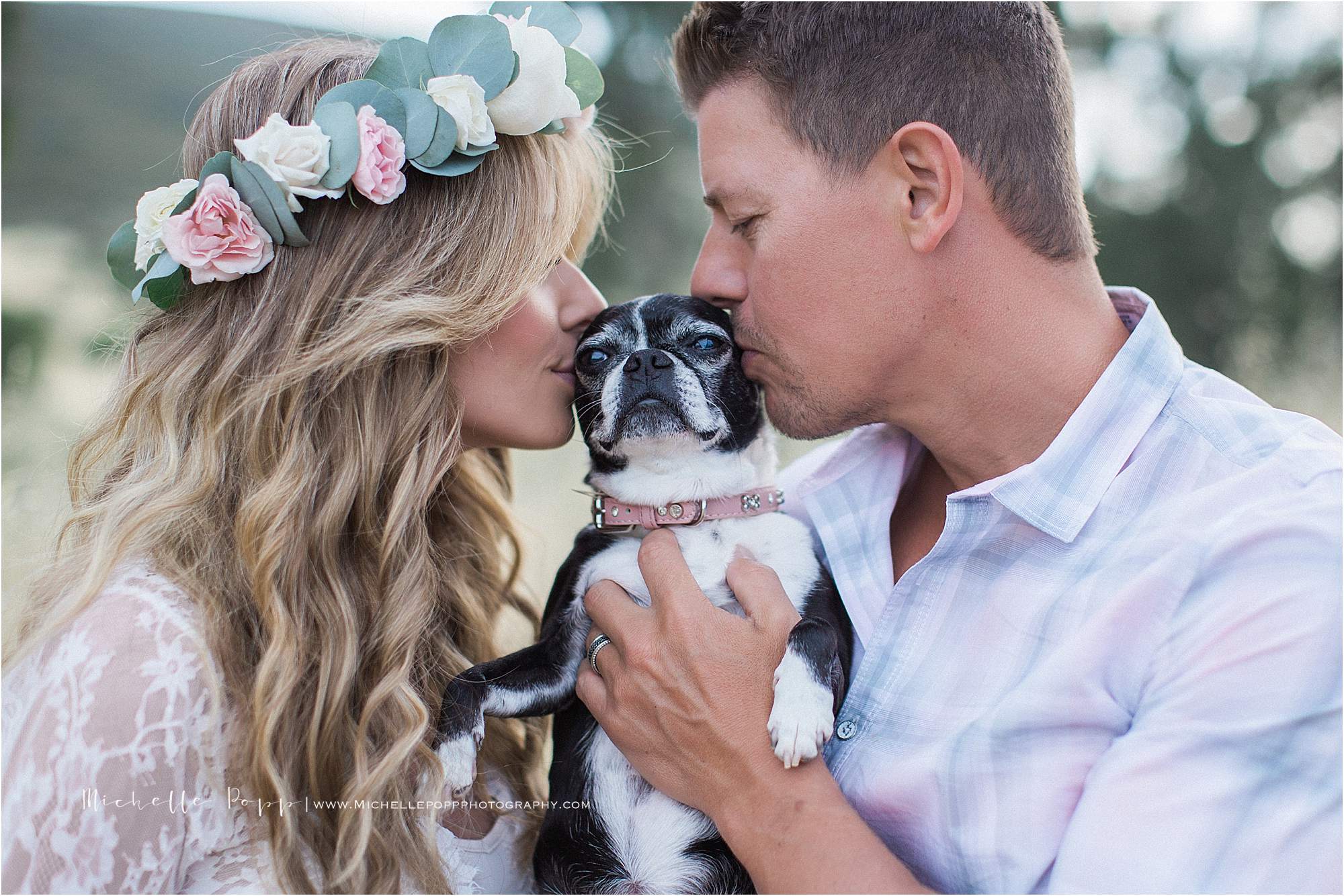 mom and dad kissing fur baby in maternity photo
