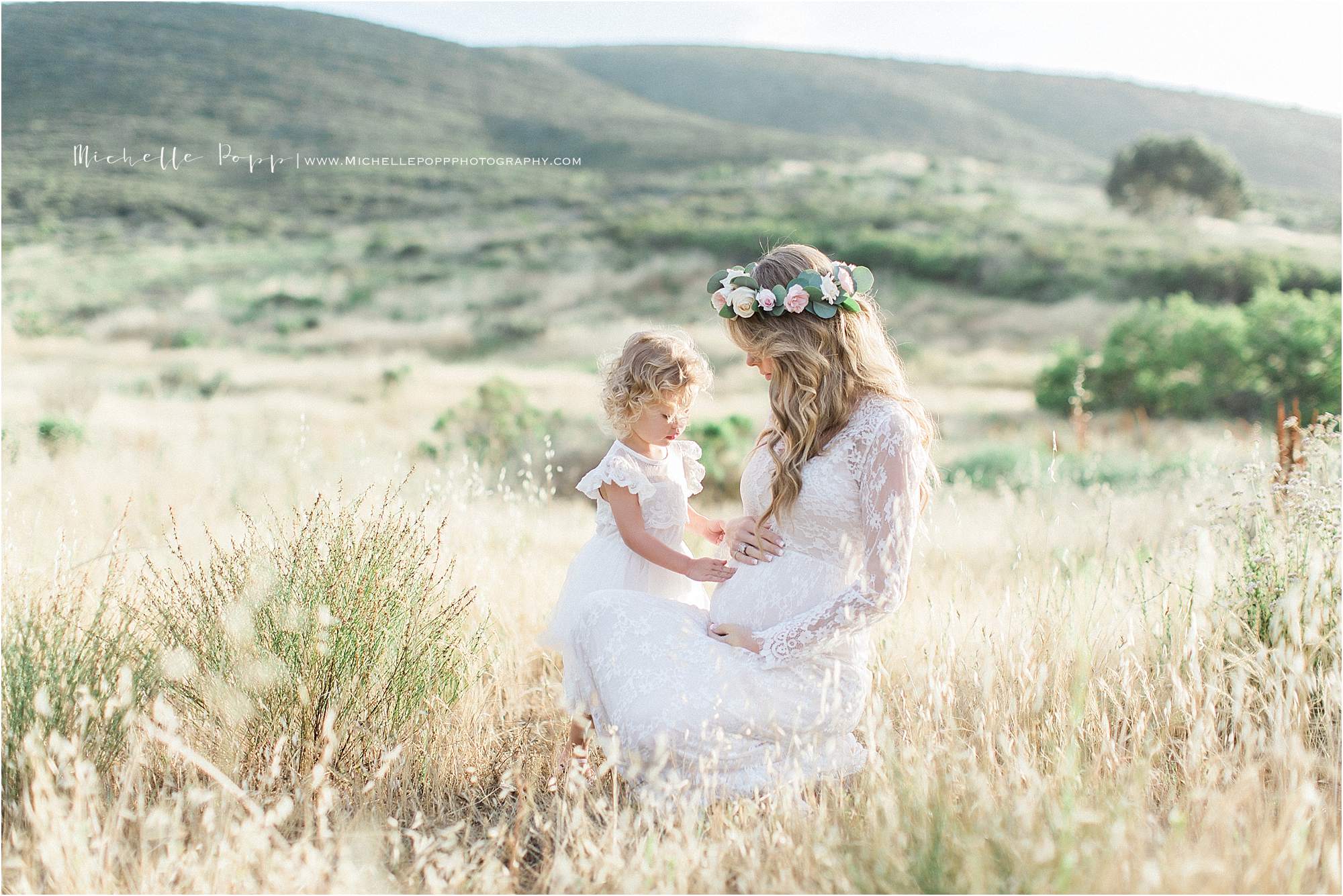 daughter touching mom's baby bump