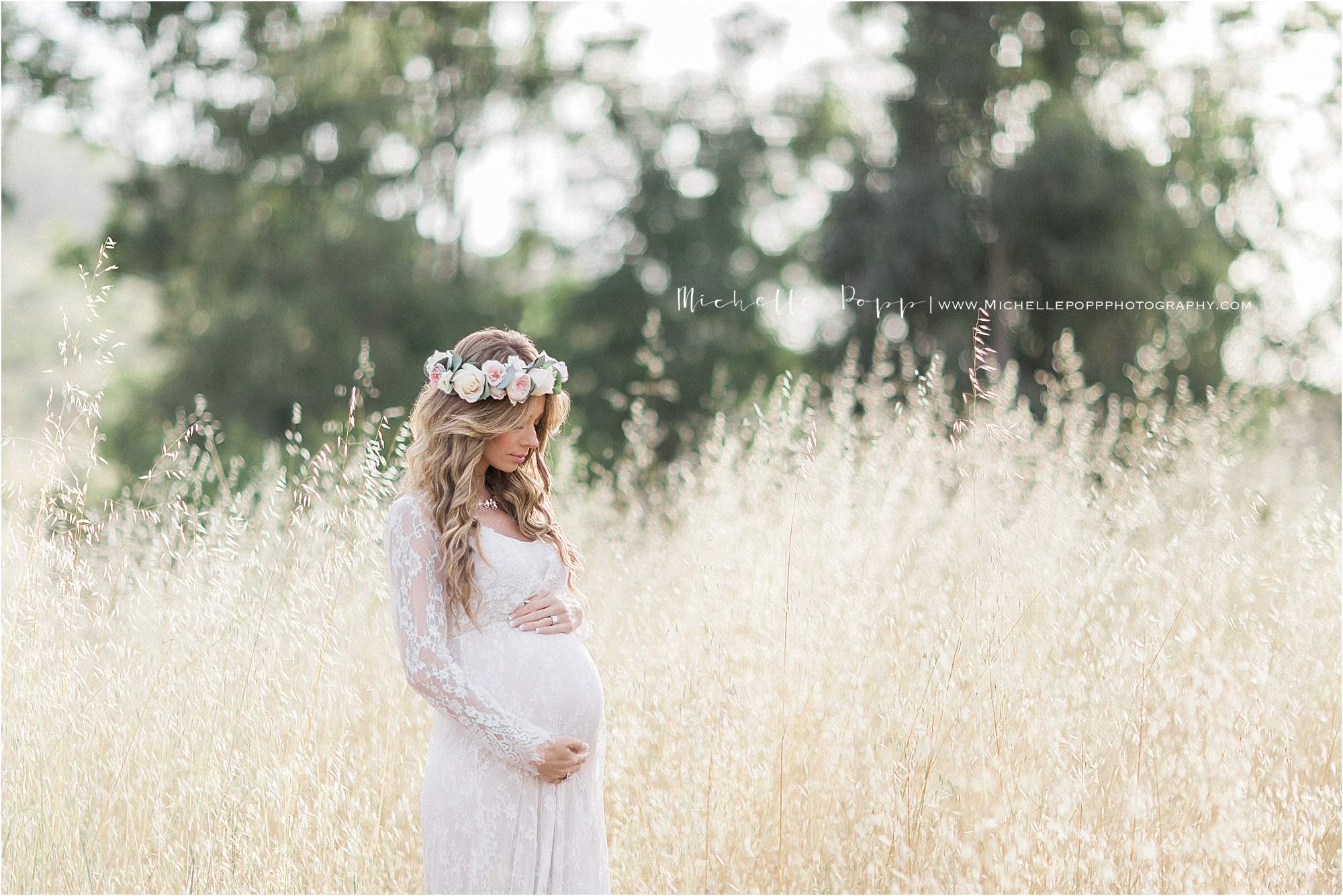 maternity shot of mom with a floral crown in a field with tall grass