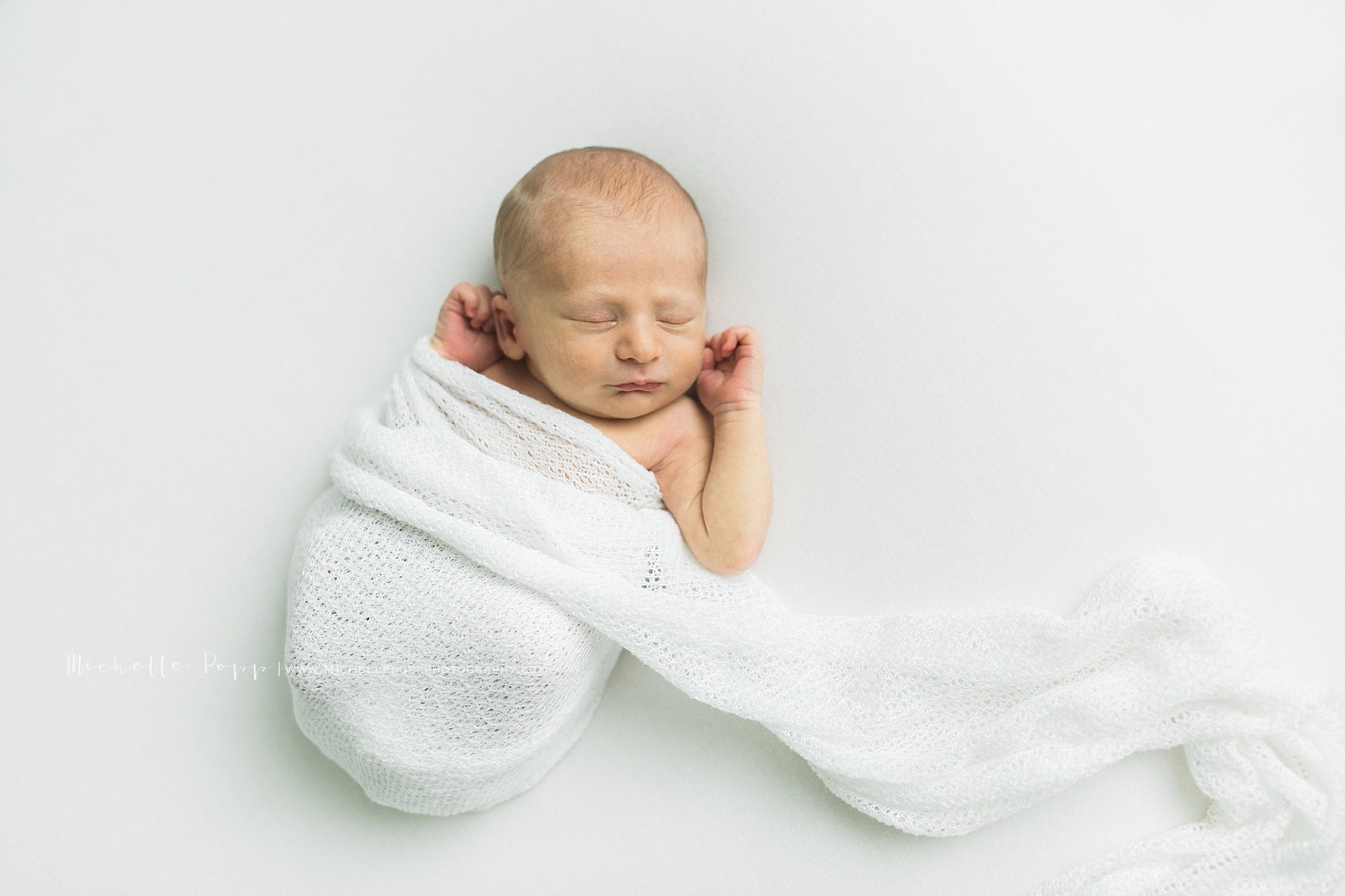 Baby in unraveling white swaddling