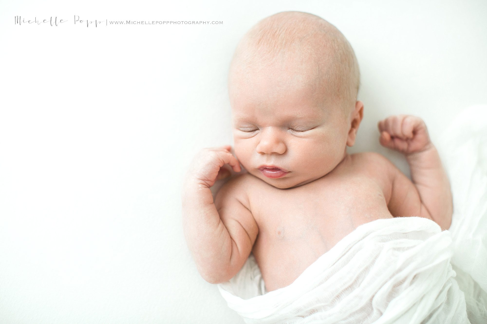 Sleeping baby with white swaddle 