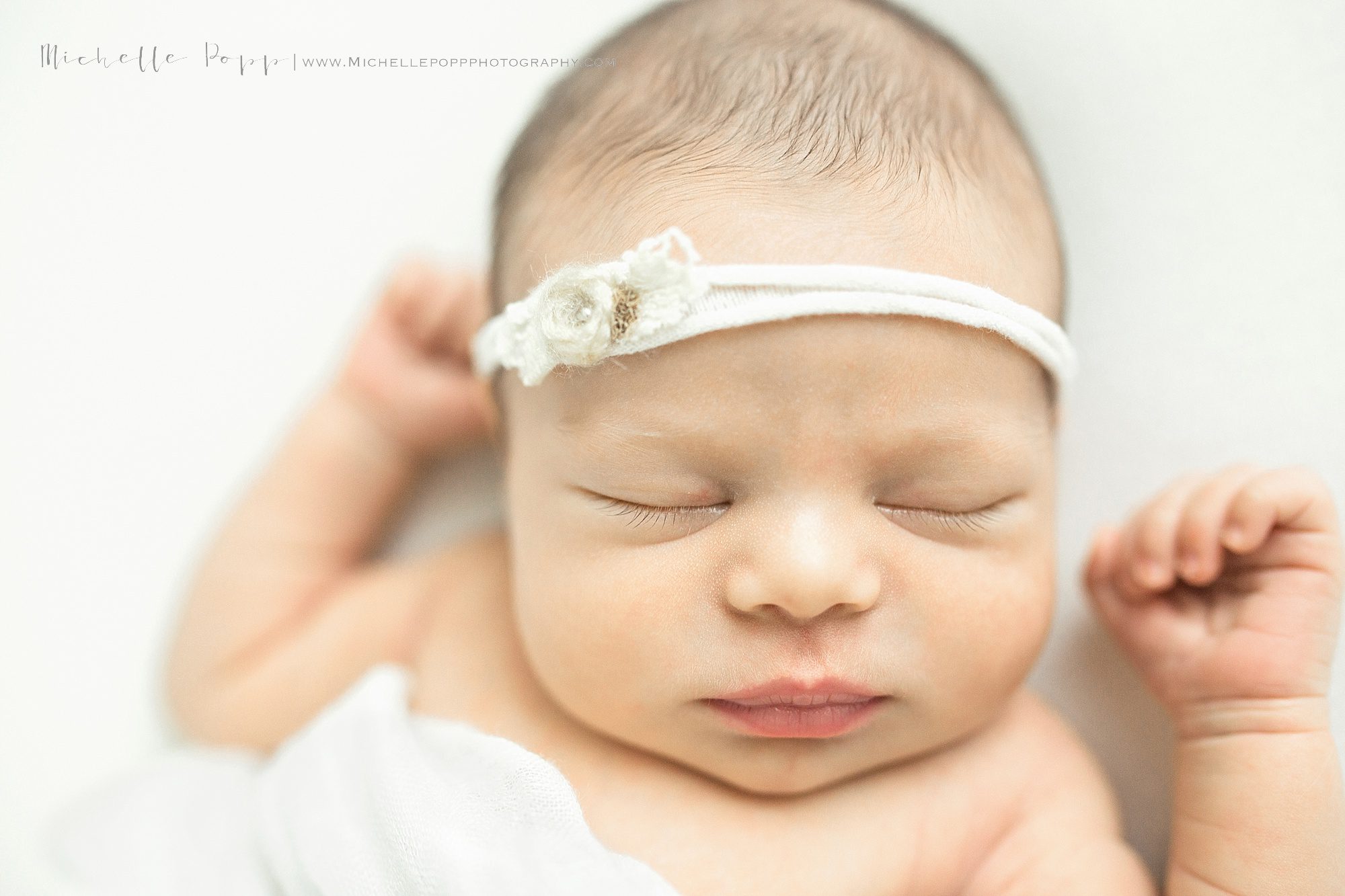 Close up of newborn baby girl with headband 