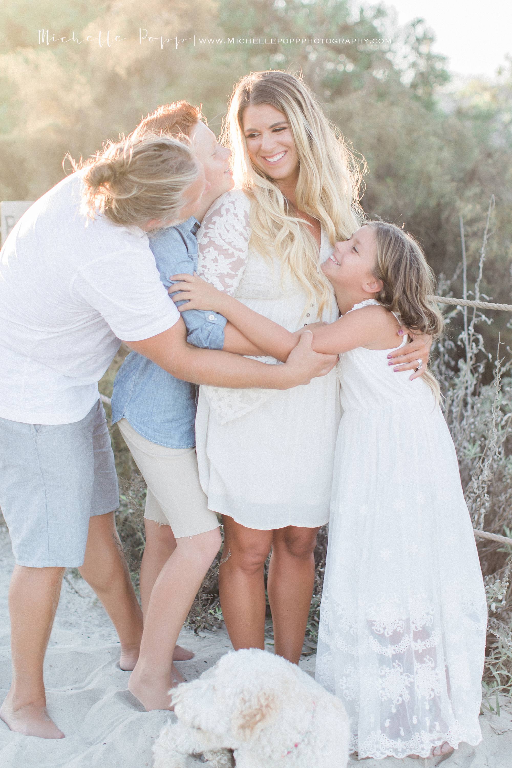 San Diego family beach photography everyone smiling and hugging mom