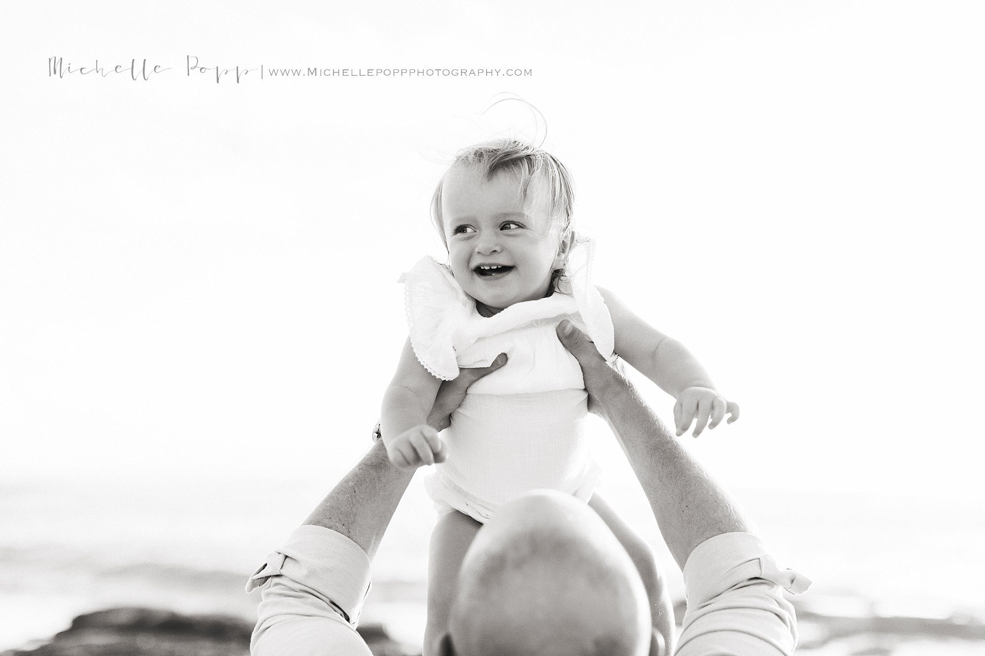 close up photo of dad throwing baby in air