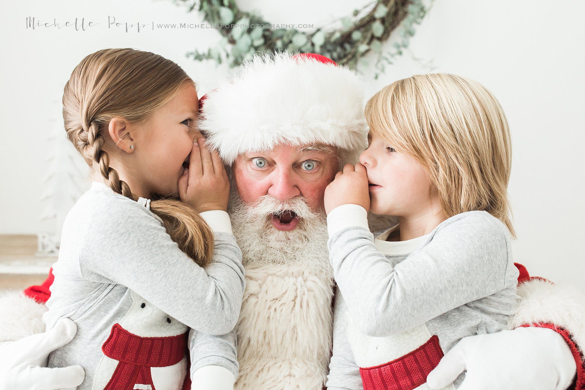 boy & girl whispering into Santa's ear