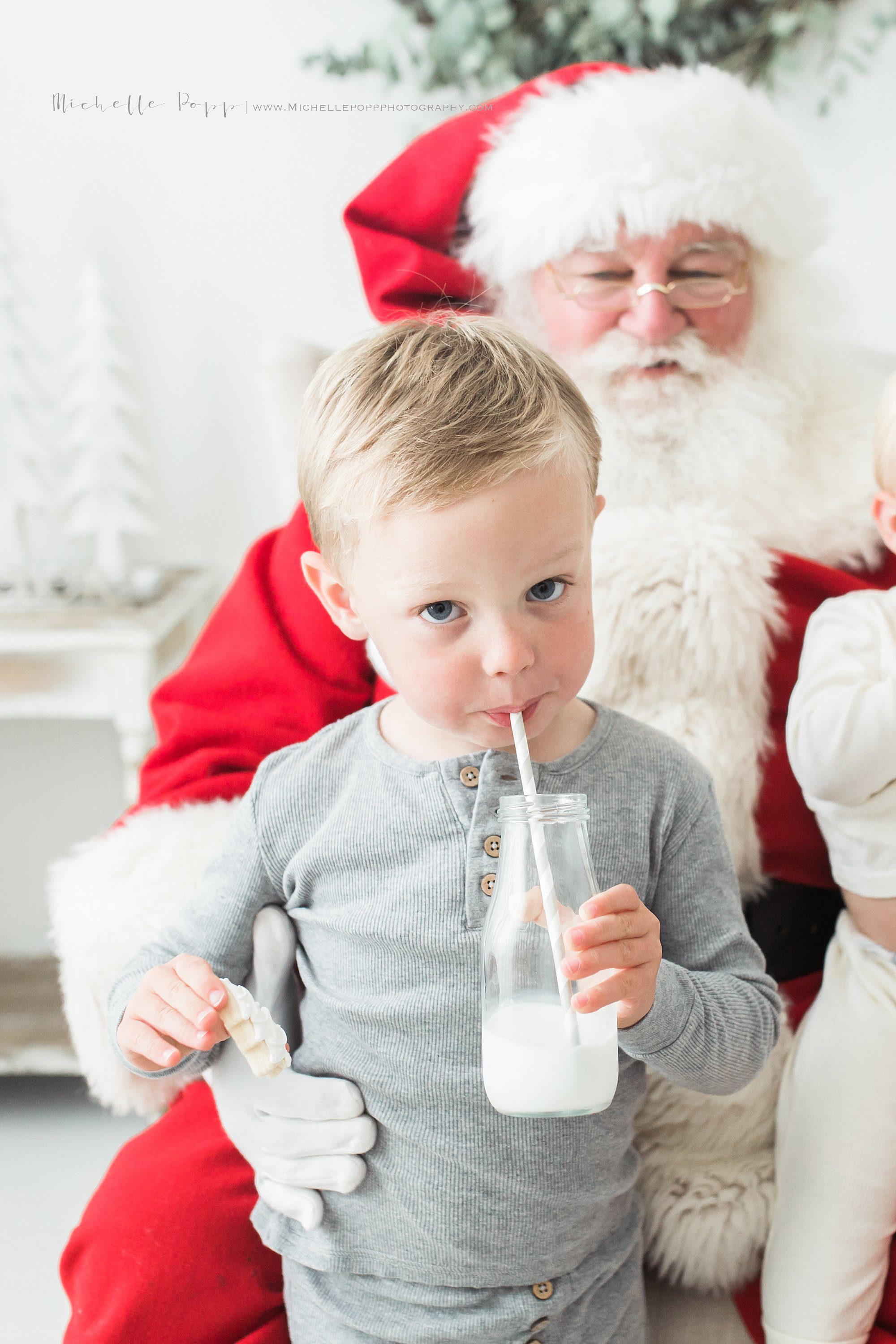 little boy enjoying milk & cookies with Santa