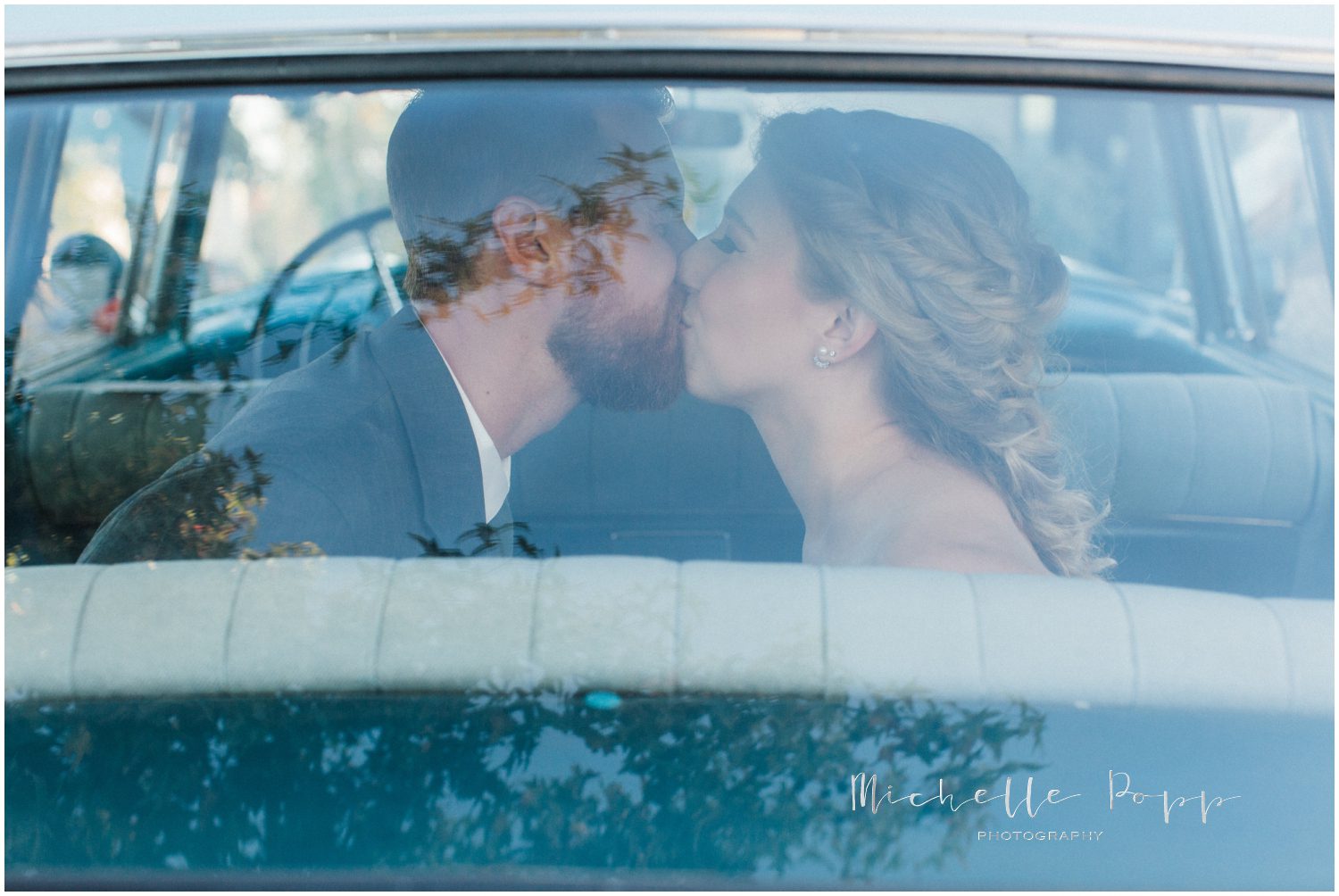 bride and groom in antique car kisses