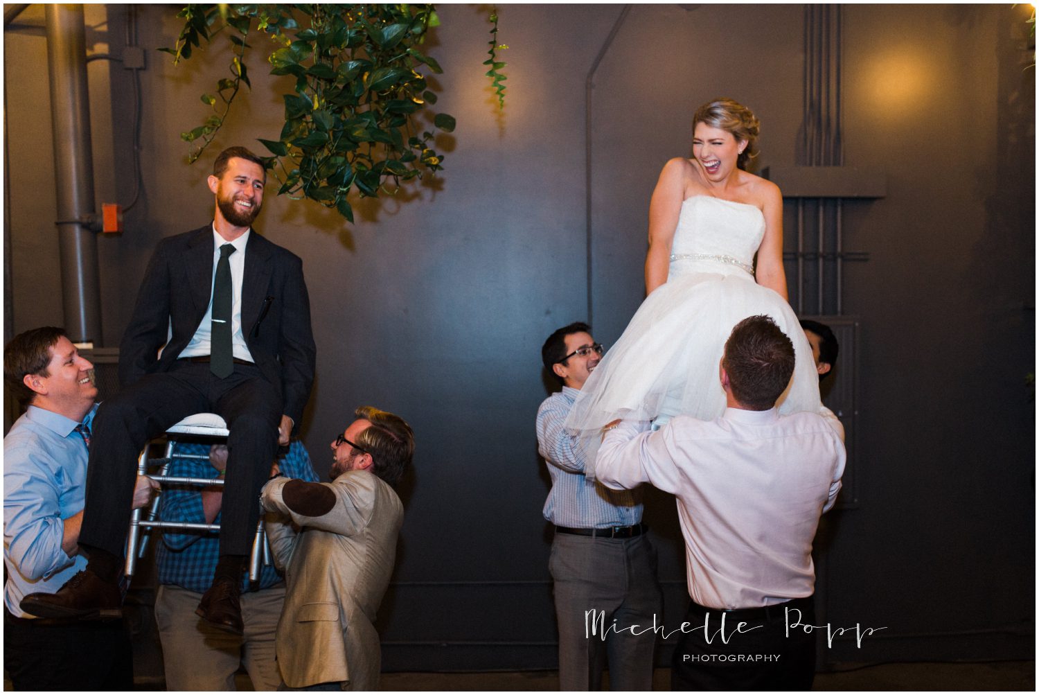 lifting the bride and groom in their chairs