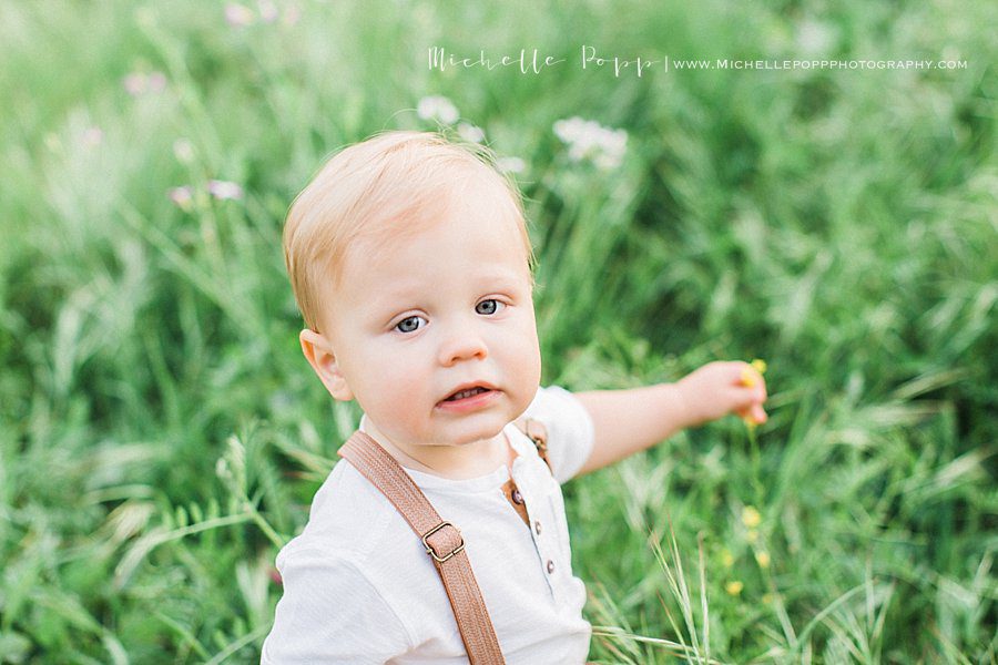 curious child looking at the wildflowers during child portrait session