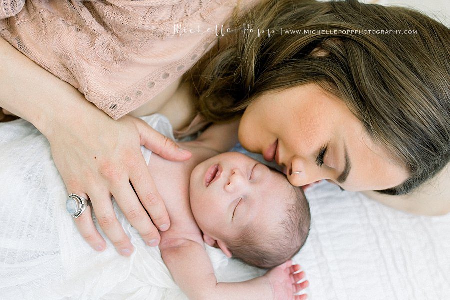 mother and baby sleeping together during a newborn photography session