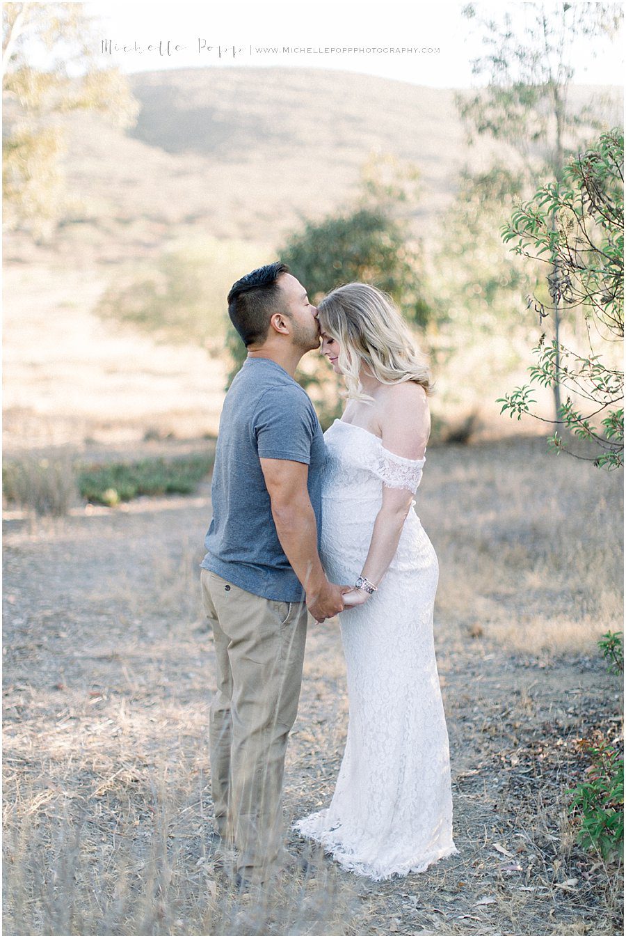 husband kissing his wife's head in a gorgeous field in San Diego