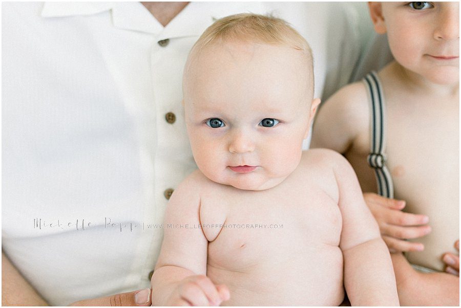 baby and his older brother with a curious look as they turn towards the camera