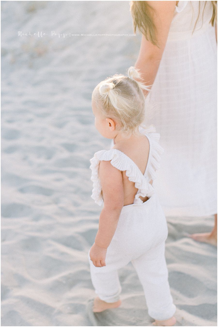 picture of a mother and daughter walking on the beach taken by a San Diego family photographer