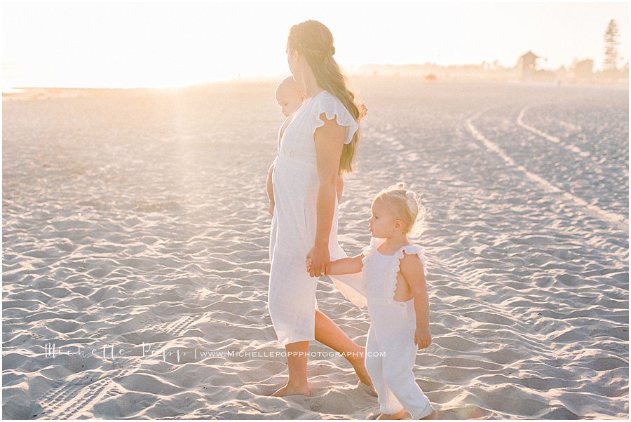 family walking across the sand at Coronado Beach in San Diego