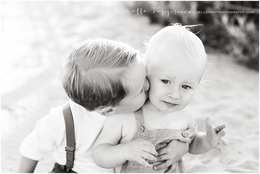 older brother kissing baby brother 