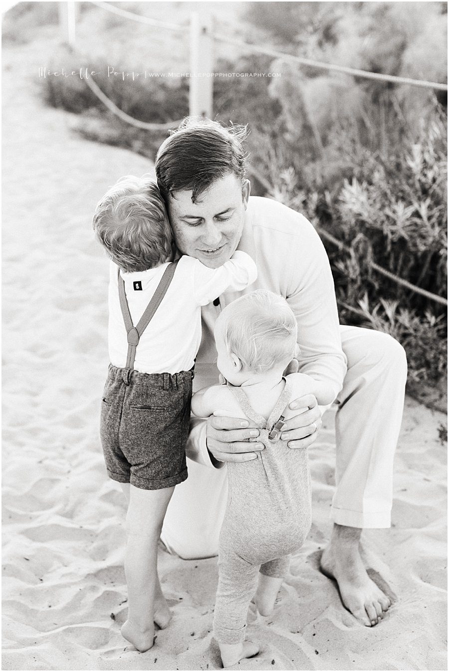 son hugging dad on the beach