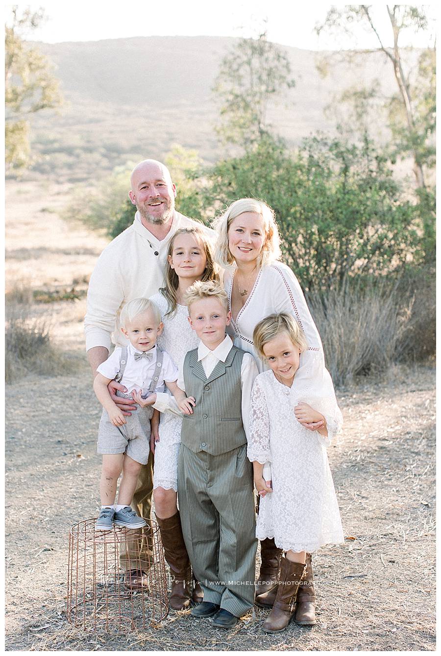 family of six in field smiling at camera