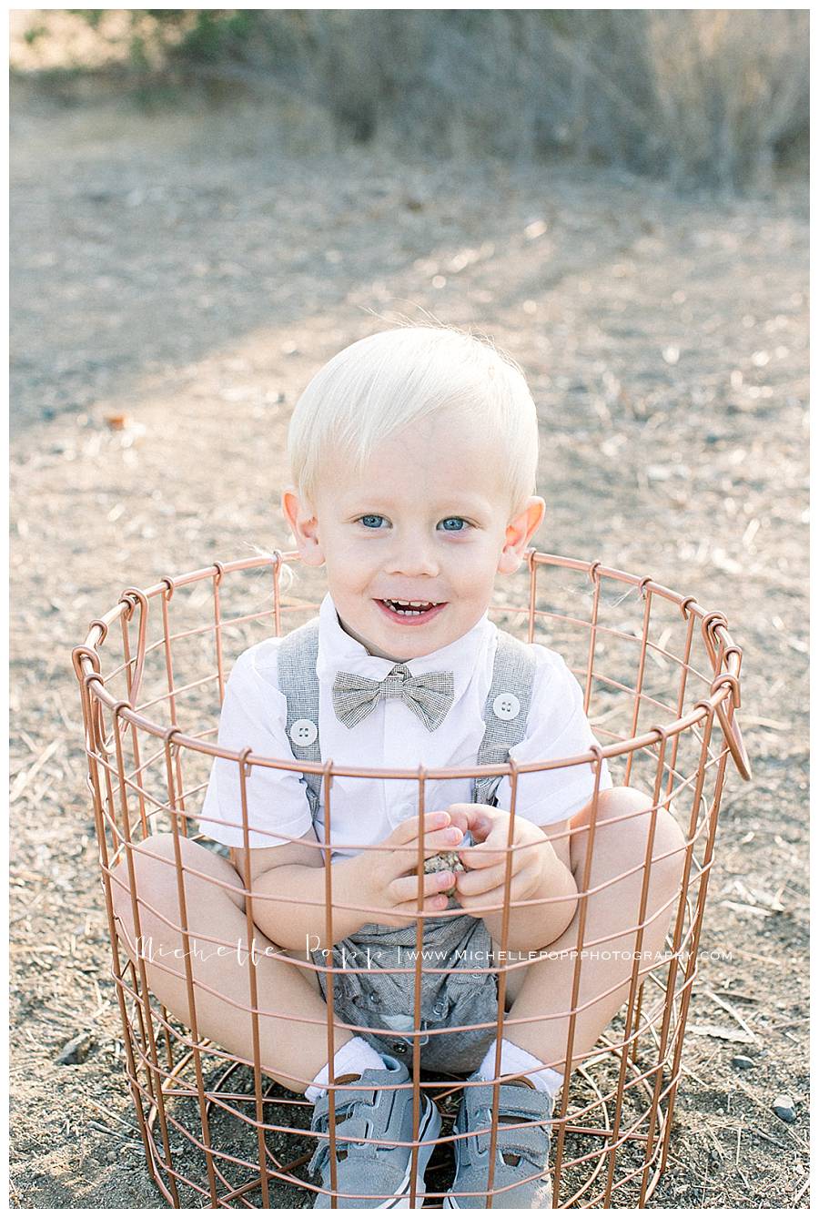 boy smiling sitting in basket