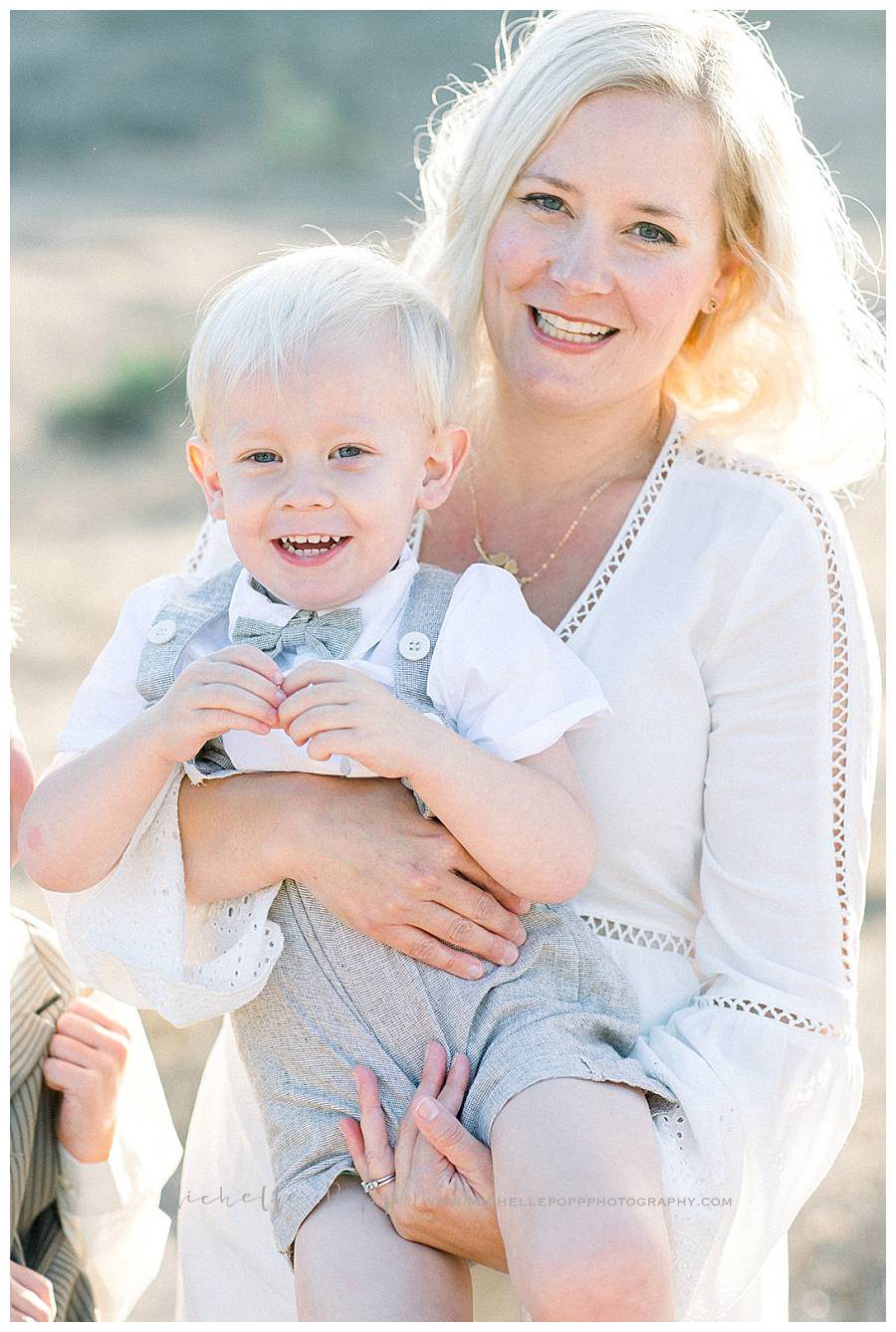 mom holding baby boy in arms smiling