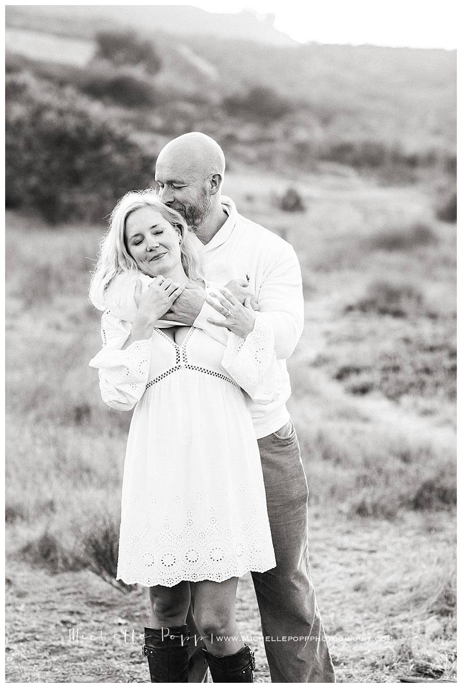 black and white mom and dad hugging each other