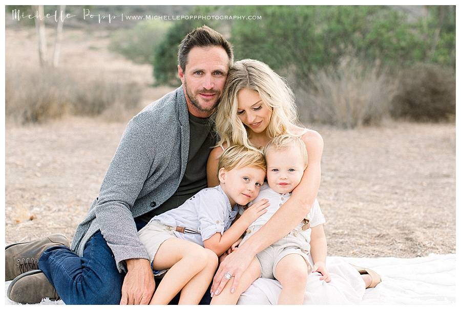 family of four in field looking down