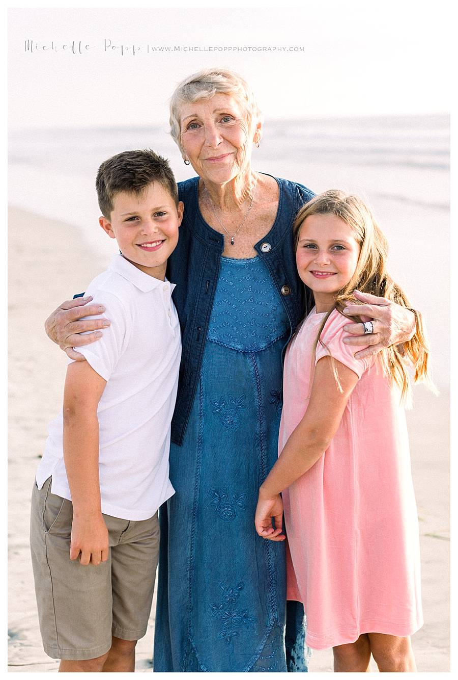 grandma hugging two kids at beach