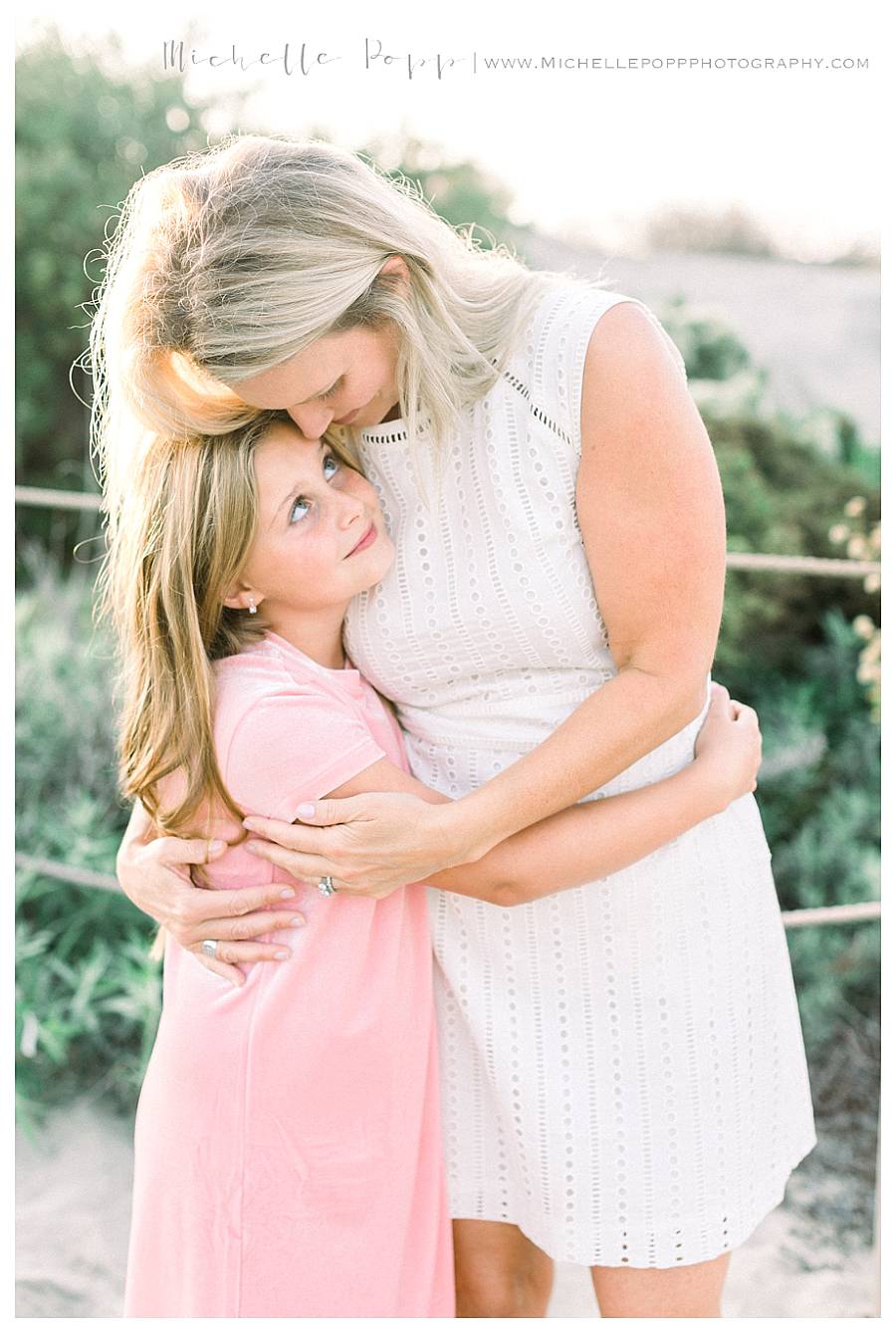 girl hugging mom while smiling up at her