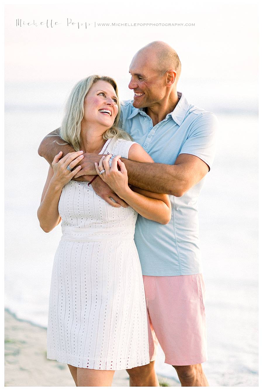 woman in white dress and man in blue shirt hugging