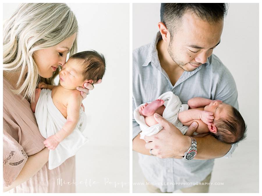 mom and dad snuggling newborn baby