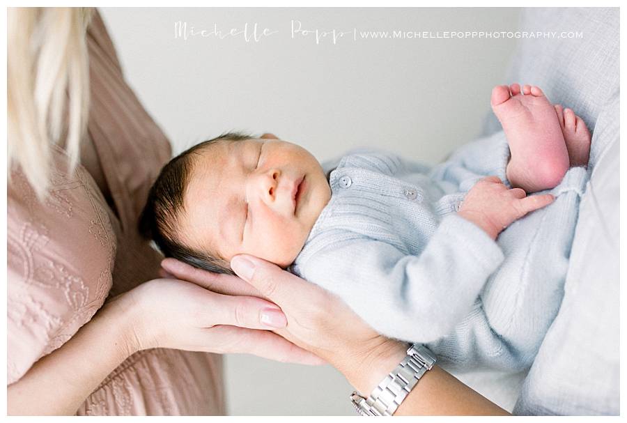 newborn baby boy in blue onesie