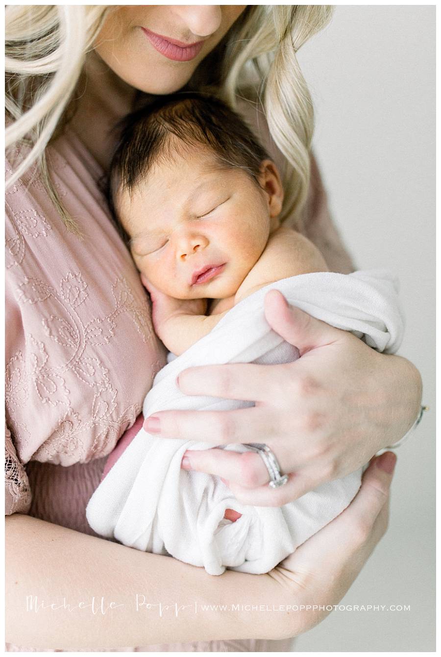 newborn baby snuggled into moms chest