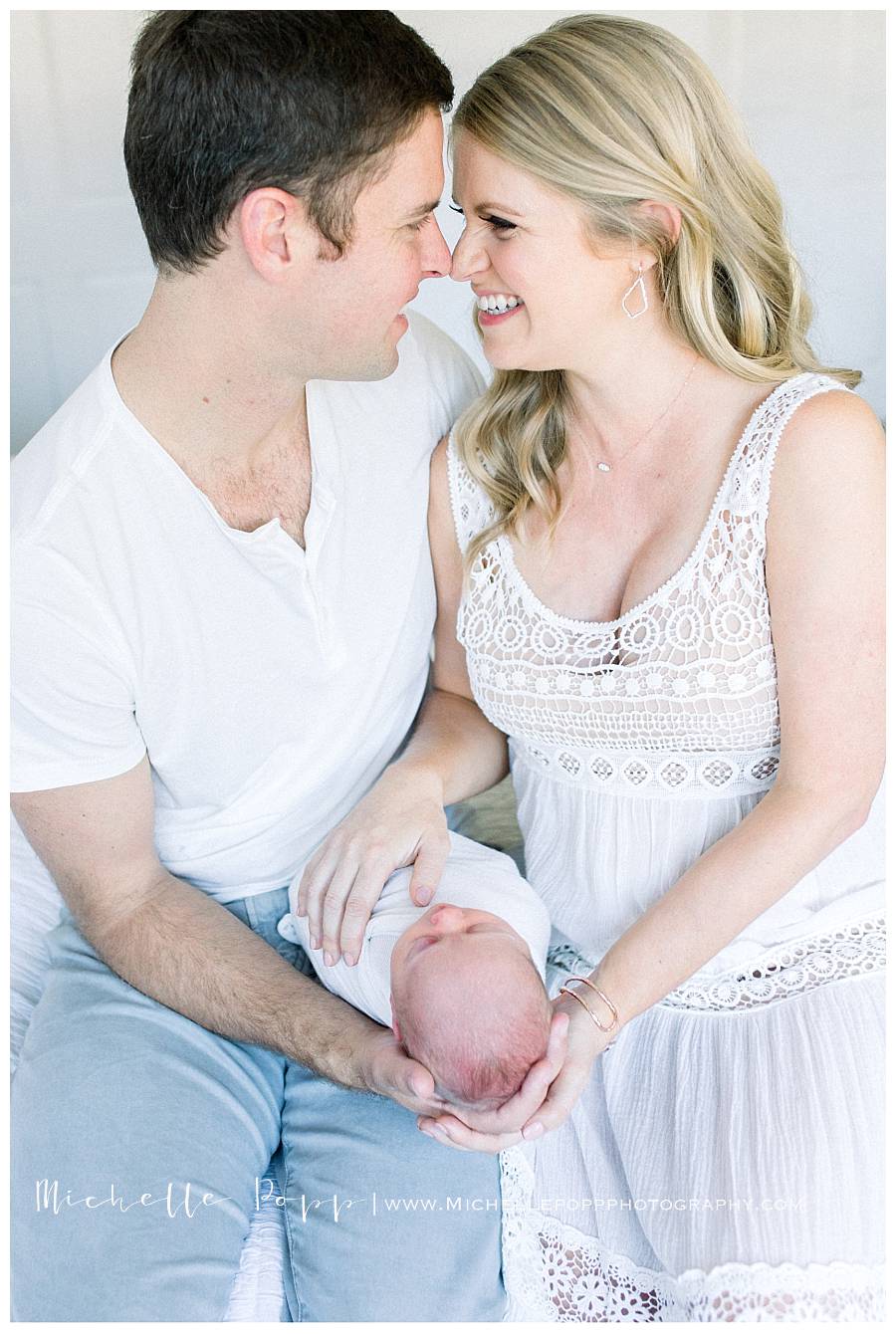 mom and dad on bed with newborn