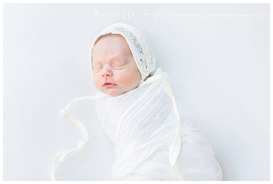 newborn baby girl in bonnet