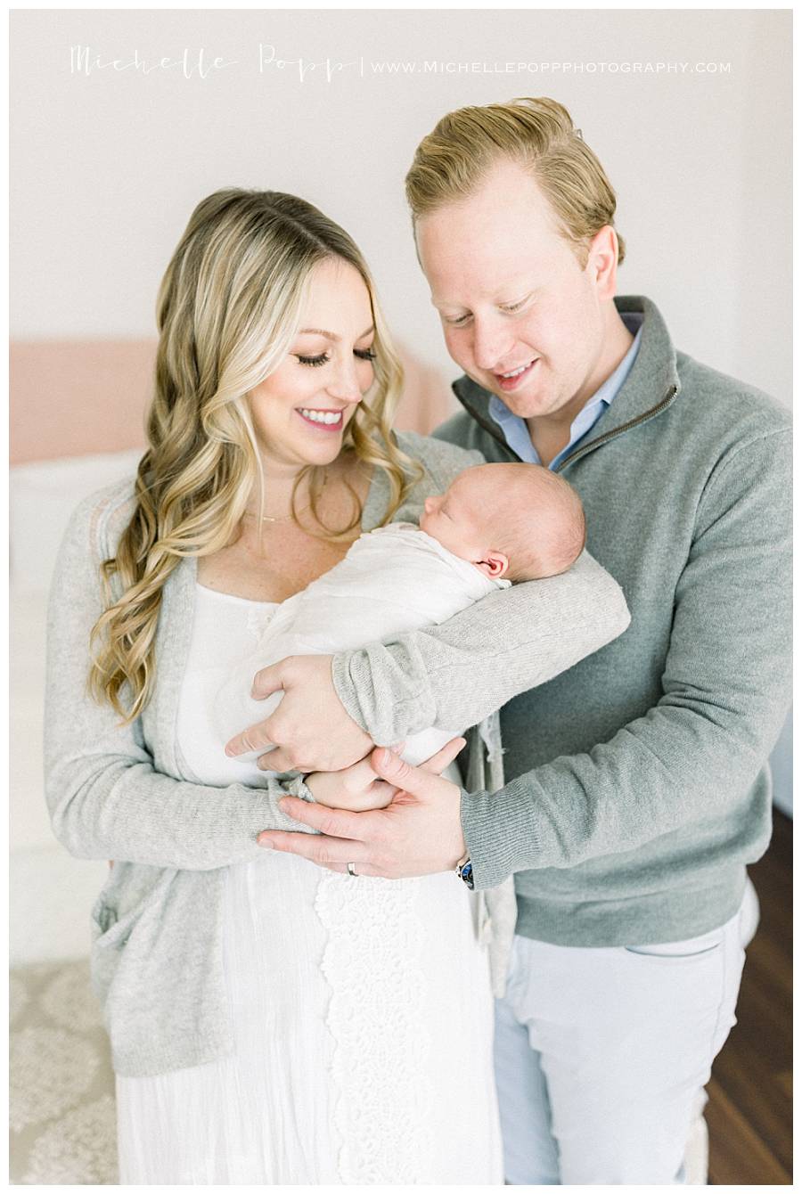 mom holding newborn baby with dad 