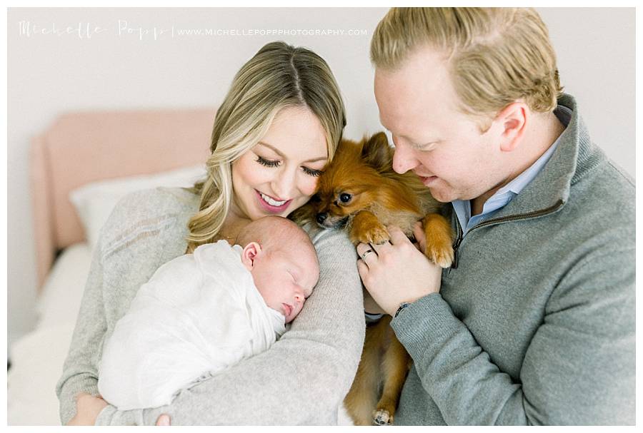 dad and puppy looking at baby