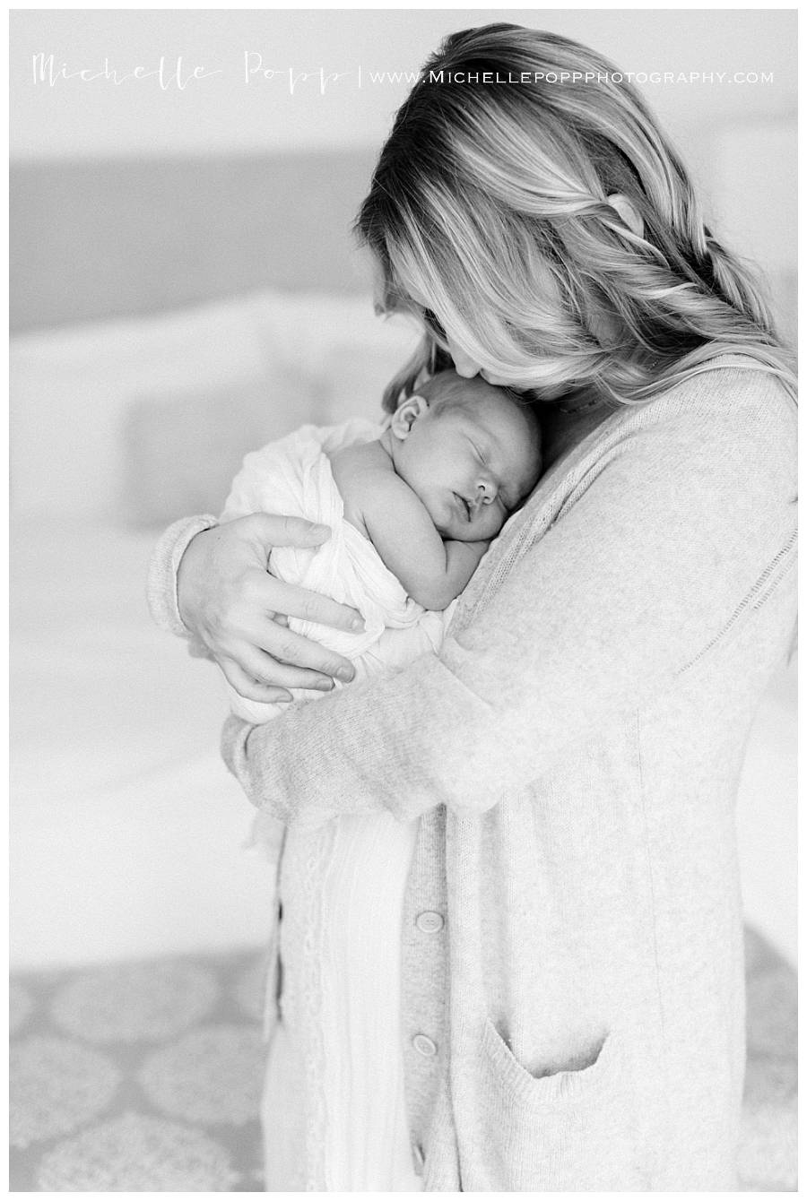 black and white mom holding baby in swaddle