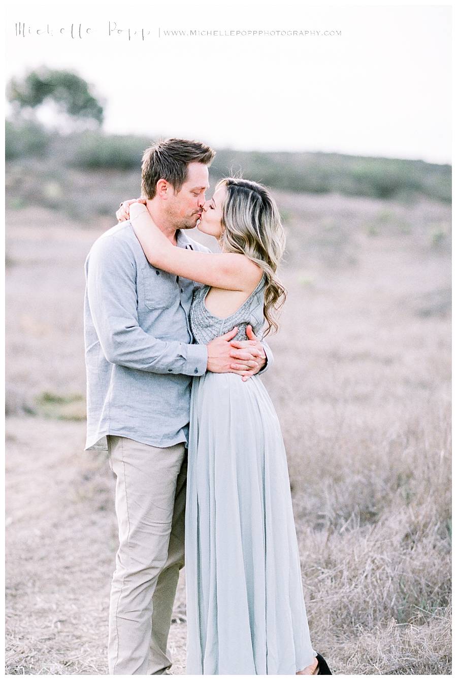 couple kissing in field