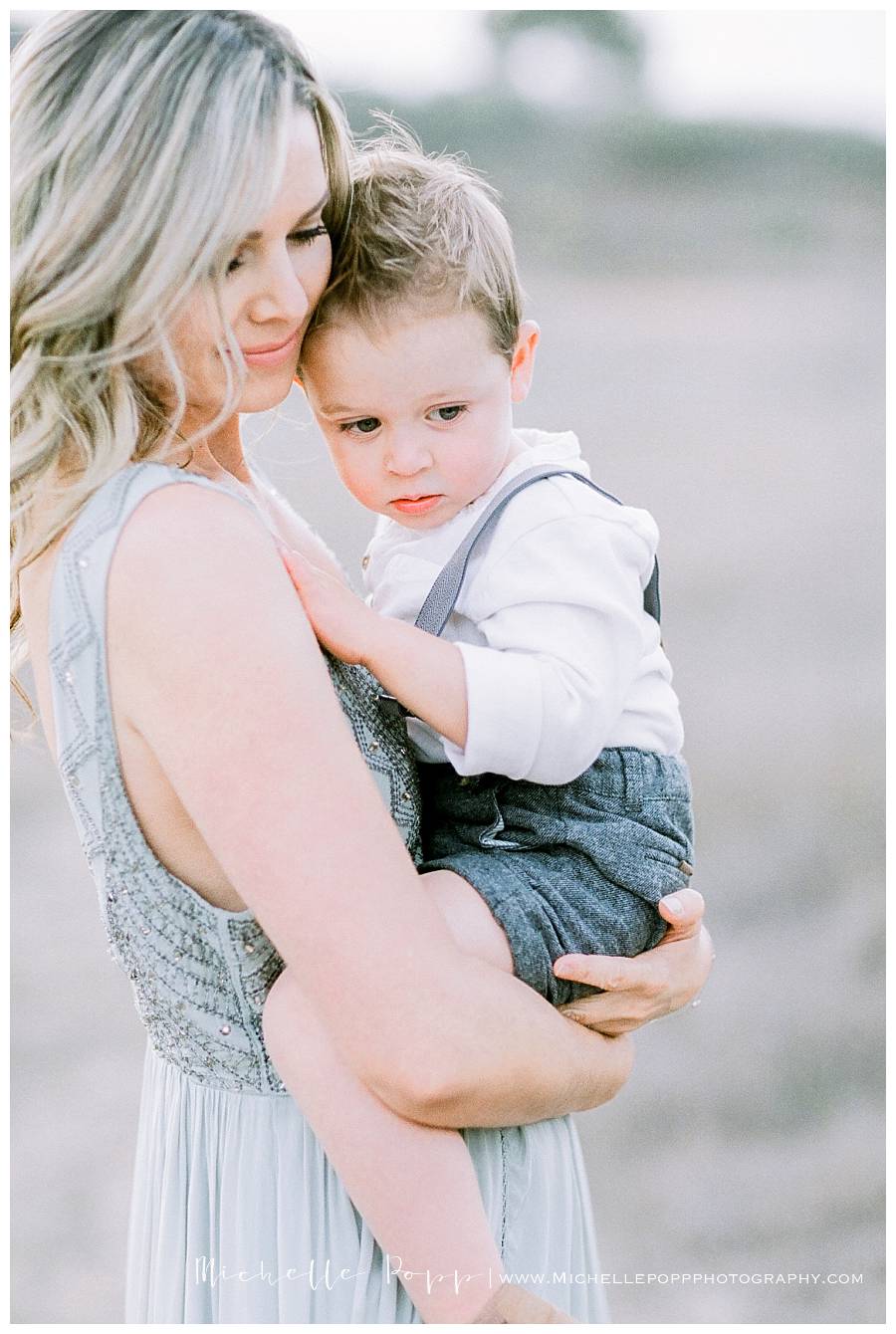 mom snuggling baby boy in arms