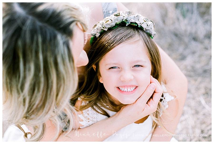 daughter looking up at camera and smiling with mom