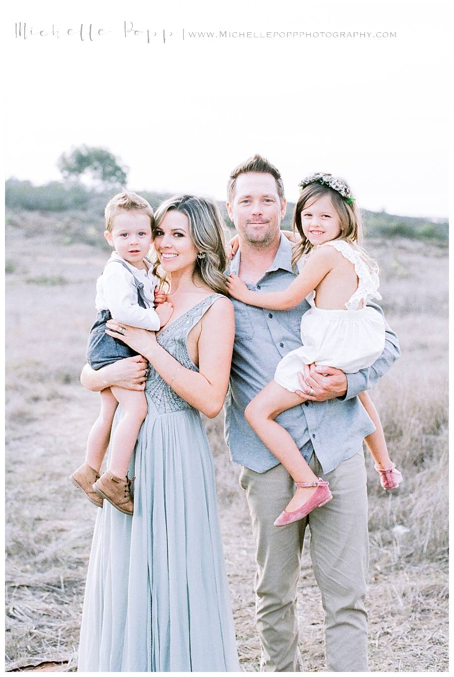 family of four in field smiling