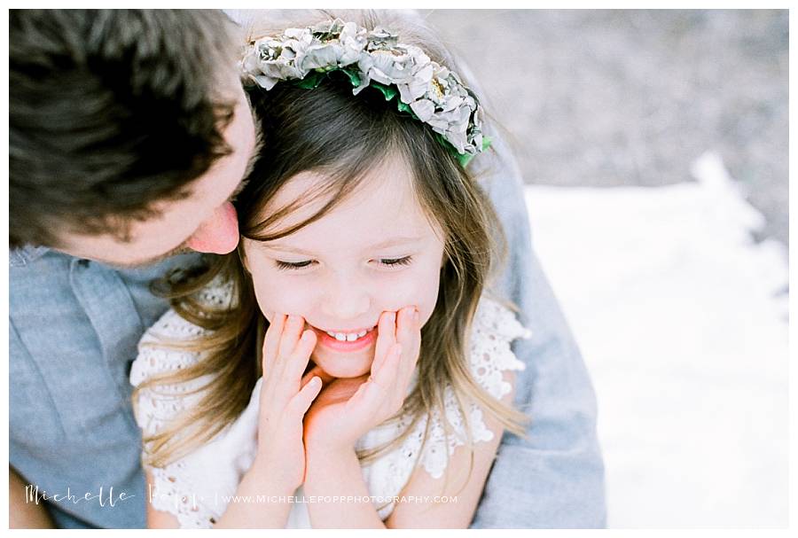 little girl holding her face and smiling