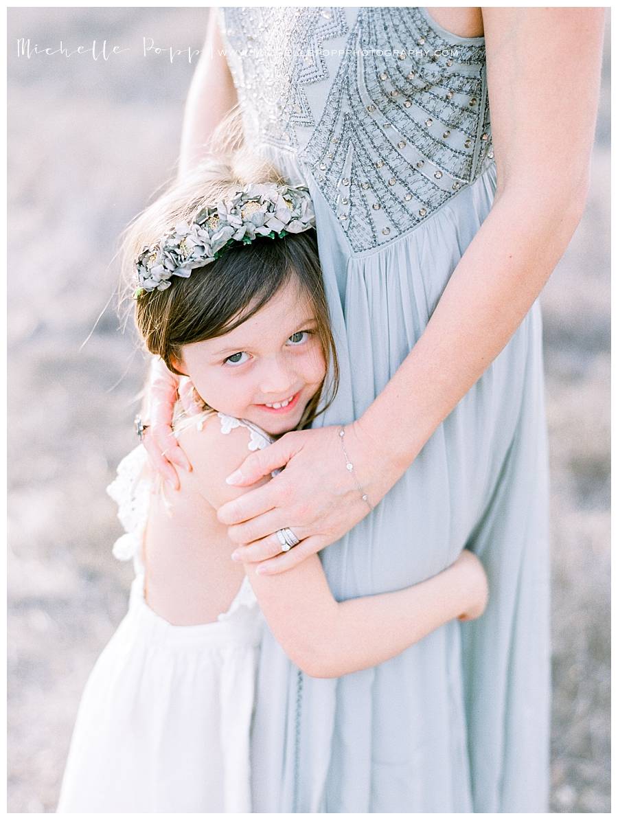 little girl hugging moms legs