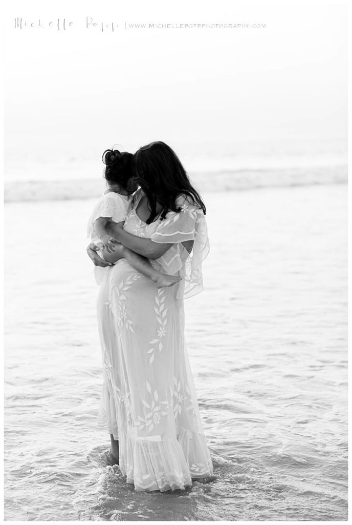 black and white of mom holding daughter in arms