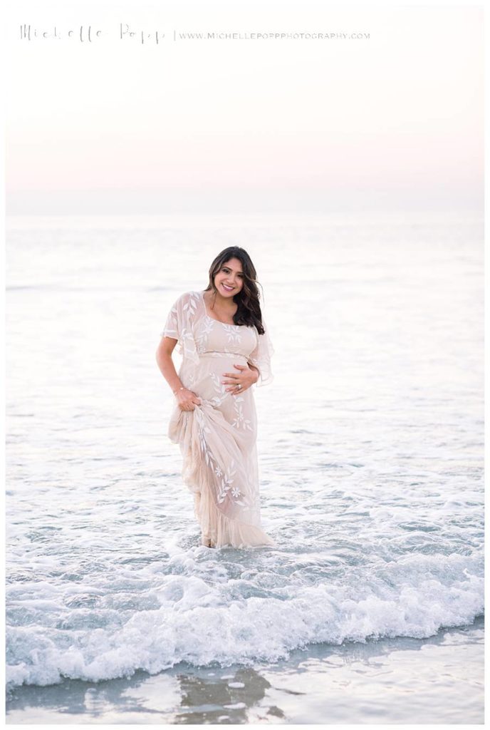 woman walking in ocean with pink dress