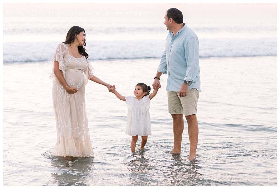 family of three at the beach in the water