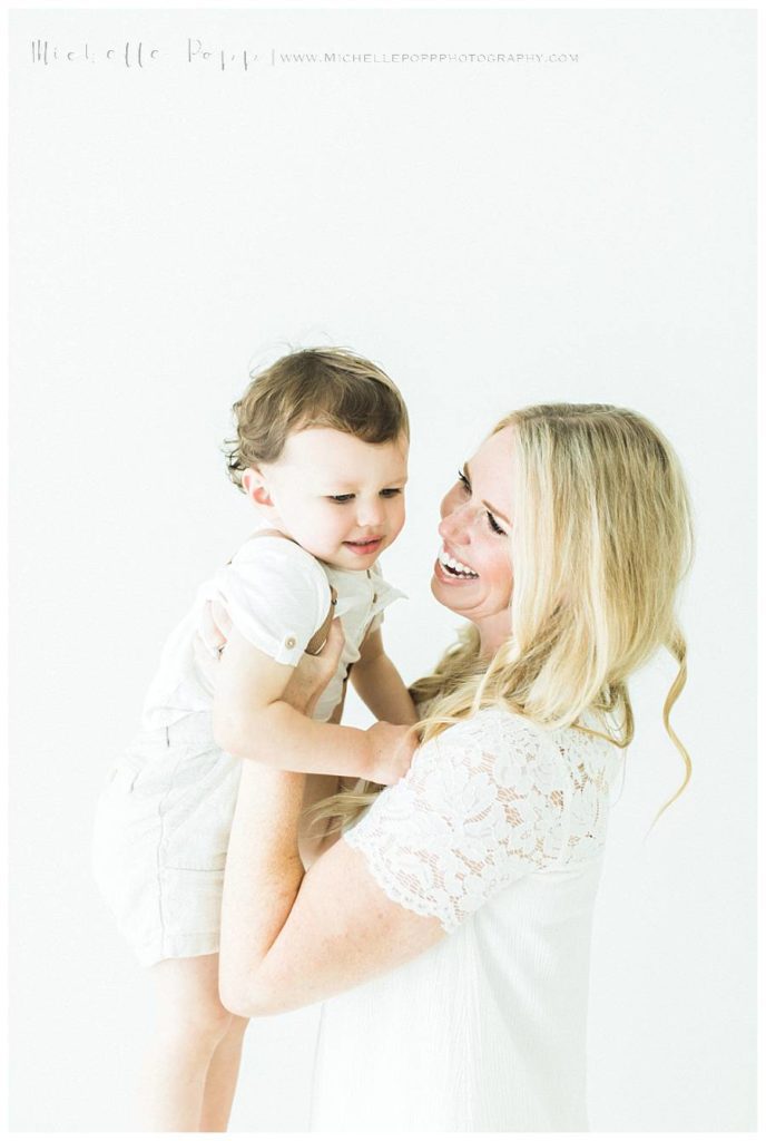 mom smiling at little boy in arms