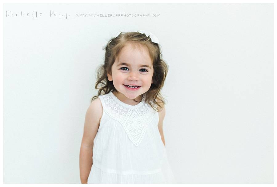 little girl in white dress smiling
