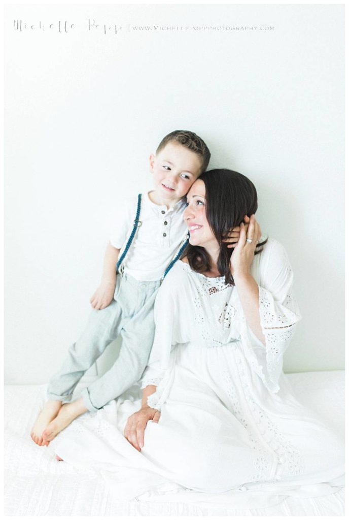 little boy holding mom as she smiles at him