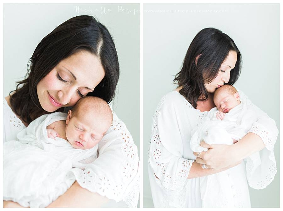 mom kissing new baby in arms